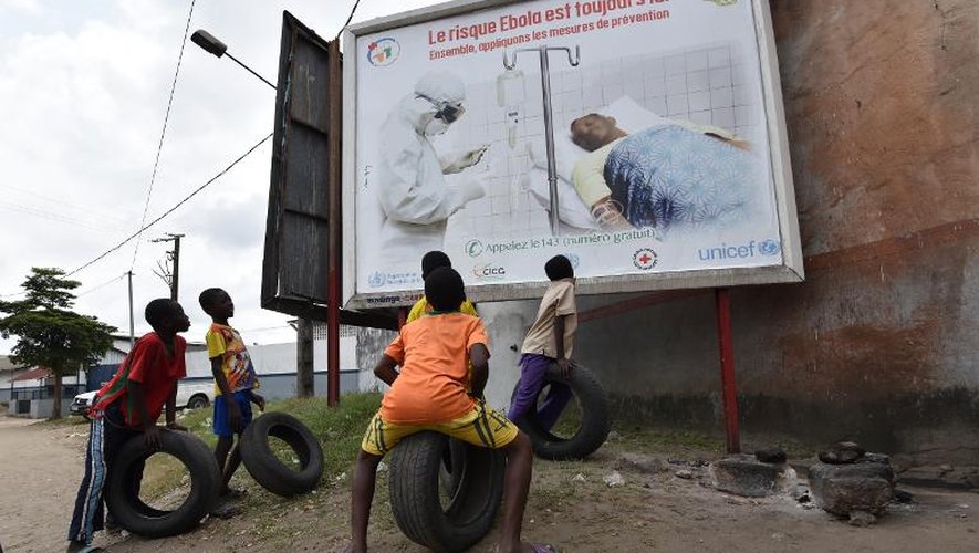 Des enfants regardent une affiche le 24 août 2014 mettant en garde contre le virus Ebola, à Abidjan