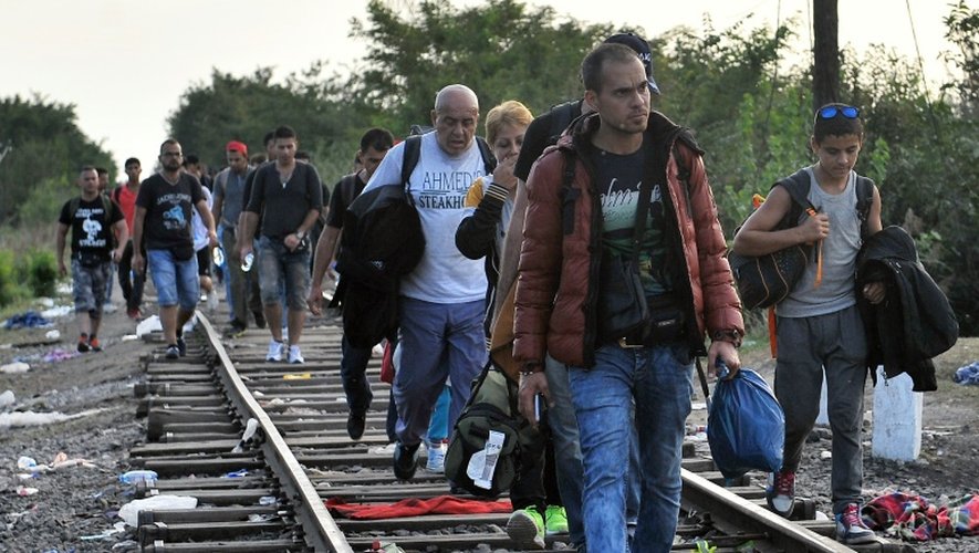 Migrants et réfugiés marchent le 15 septembre 2015 le long de la voie ferrée  près de Horgos en Serbie