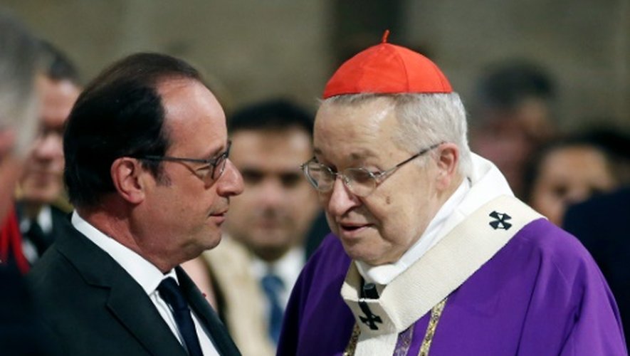 Le président François Hollande s'adresse à l'archevêque de Paris le cardinal André Vingt-trois, avant une messe à Notre-Dame de Paris, le 27 juillet 2016
