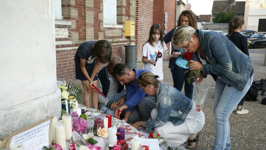 Fleurs et bougies déposées par des habitants devant la mairie le 26 juillet 2016 à Saint-Etienne- du-Rouvray où un prêtre a été égorgé dans l'église
