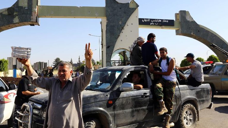 Des combattants islamistes de Fajr Libya montent la garde à l'entrée de l'aéroport de Tripoli le 24 août 2014