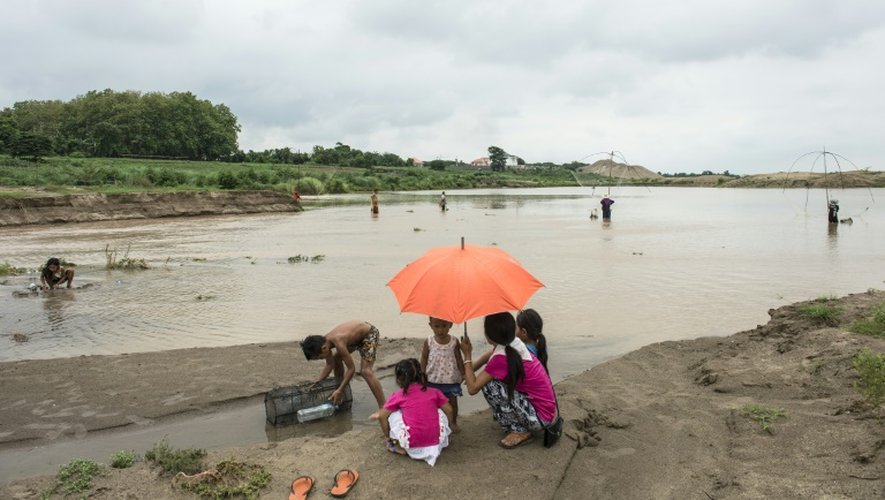 Des familles pêchent à proximité d'un site d'extraction de sable au bord de la rivière Mékong à Ventiane au Laos, le 31 mai 2016
