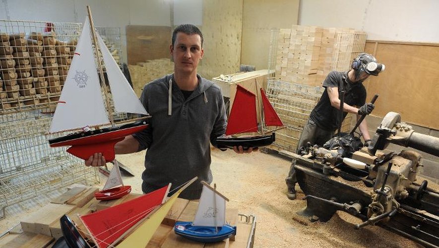 Nicolas Tirot (g), le patron du fabricant Tirot, pose avec des jouets-bateaux en bois à côté d'un employé au travail, le 3 décembre 2013 à Romagné (Ille-et-Vilaine)