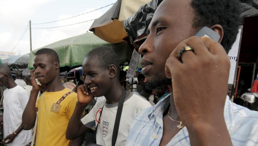 Des hommes au téléphone sur leur portable à Abidjan en Côte d'Ivoire, le 23 juin 2009