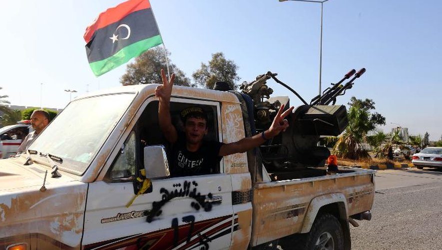 Un combattant islamiste de Fajr Libya fait le signe de la victoire à l'entrée de l'aéroport de Tripoli le 24 août 2014