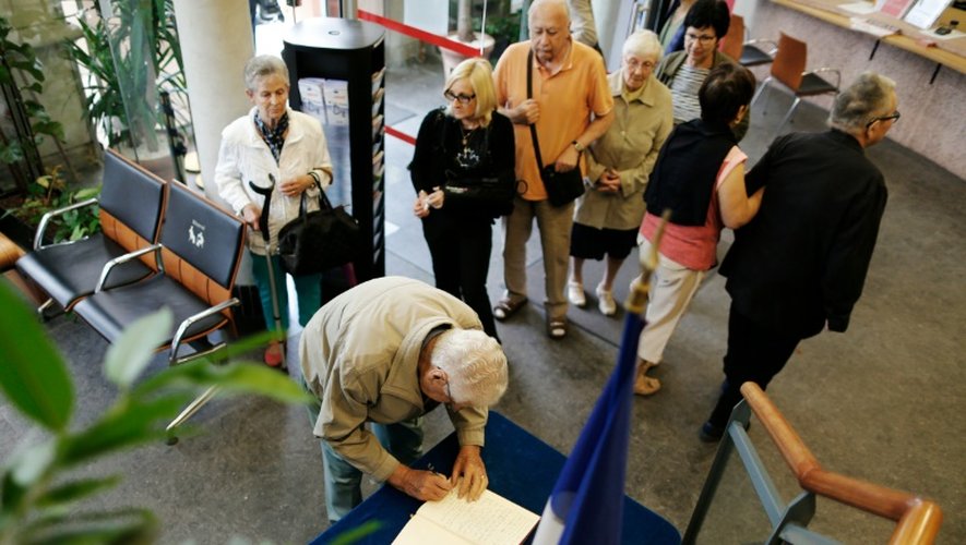 Des habitants font la queue pour signer le registre de condoléances le 27 juillet 2016 à la mairie deSaint-Etienne-du-Rouvray