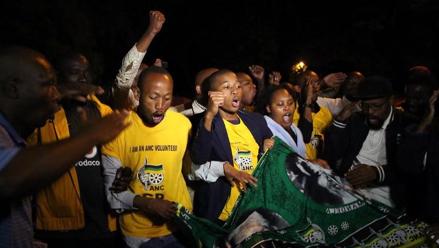 Des Sud-Africains chantent pour rendre hommage à Nelson Mandela, le 5 décembre 2013 à Johannesburg