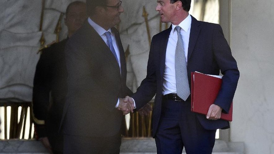 Le Premier ministre Manuel Valls (d) salue le président François Hollande alors qu'il quitte l'Elysée à Paris après une réunion pour la nomination du nouveau gouvernement le 26 août 2014