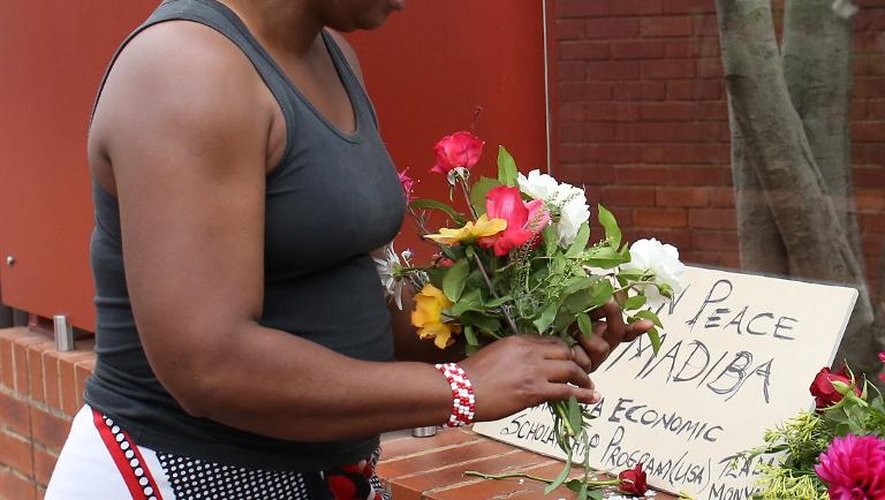 Une femme dépose des fleurs pour Nelson Mandela, après l'annonce de son décès, le 6 décembre 2013 à Soweto