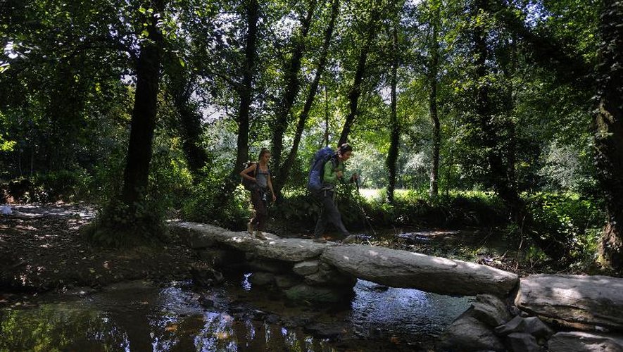 Des pélerins traversent la rivière de Catasol sur le chemin de Saint James, près du village de Melide à 60 km de Saint Jacques de Compostelle le 21 août 2014