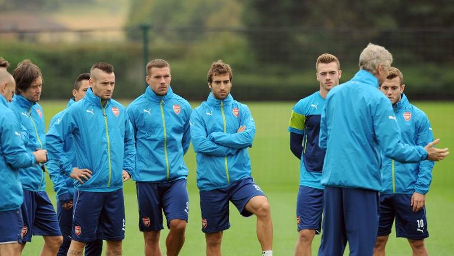 Les joueurs d'Arsenal écoutent attentivement les consignes de leur manageur Arsène Wenger lors d'une séance d'entraînement à London Colney le 26 août 2014