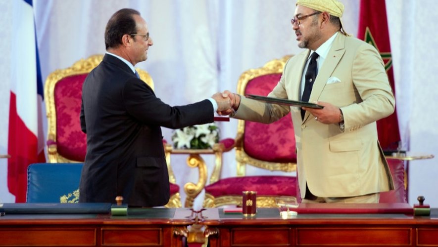 Le président François Hollande et le roi du Maroc Mohammed VI se serrent la main à Tanger le 20 septembre 2015 après la signature d'un contrat de coopération pour la COP21