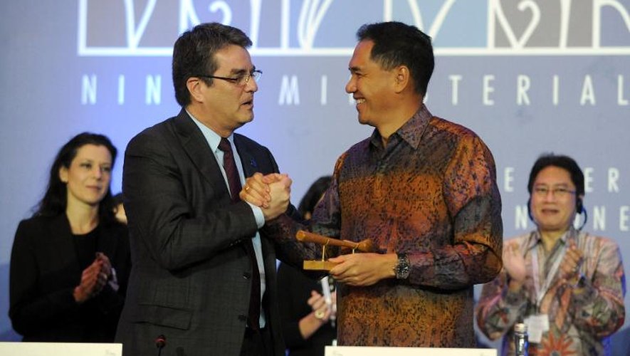 Le directeur général de l'OMC Roberto Azevedo (g) serre la main du ministre indonésien du Commerce Gita Wirjawan après un accord final, le 7 décembre 2013 à Nusa Dua, sur l'île indonésienne de Bali