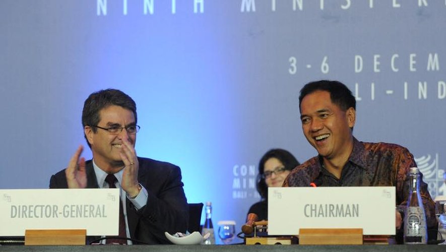 Le directeur général de l'OMC Roberto Azevedo (g) applaudit le ministre indonésien du Commerce Gita Wirjawan après un accord final, le 7 décembre 2013 à Nusa Dua, sur l'île indonésienne de Bali