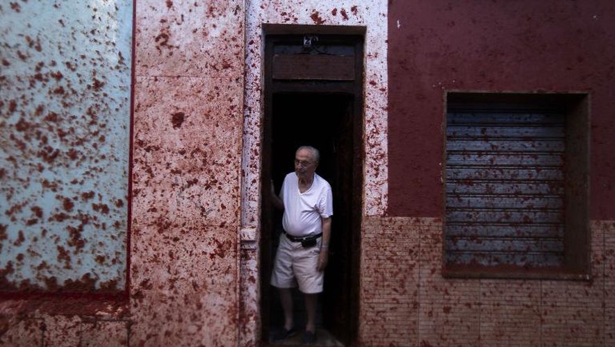 Un homme sur le pas de sa porte durant le festival de la "Tomatina" à Bunol (Espagne), plus grande bataille de tomates de la planète