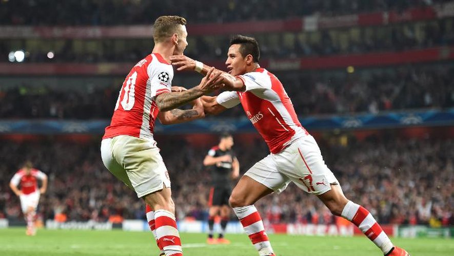 L'attaquant chilien d'Arsenal Alexis Sanchez célèbre son but avec son équipier anglais Jack Wilshere, lors du match retour de barrage qualificatif pour la phase de poule de Ligue des Champions contre Besiktas, le 27 août 2014 à Londres.