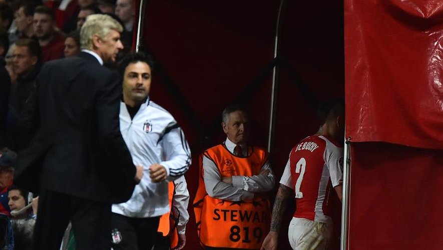 Le défenseur français d'Arsenal Mathieu Debuchy quitte la pelouse après un second carton jaune, sous le regard de son entraîneur Arsène Wenger, lors du match retour de barrage de Ligue des Champions contre Besiktas, le 27 août 2014 à Londres.