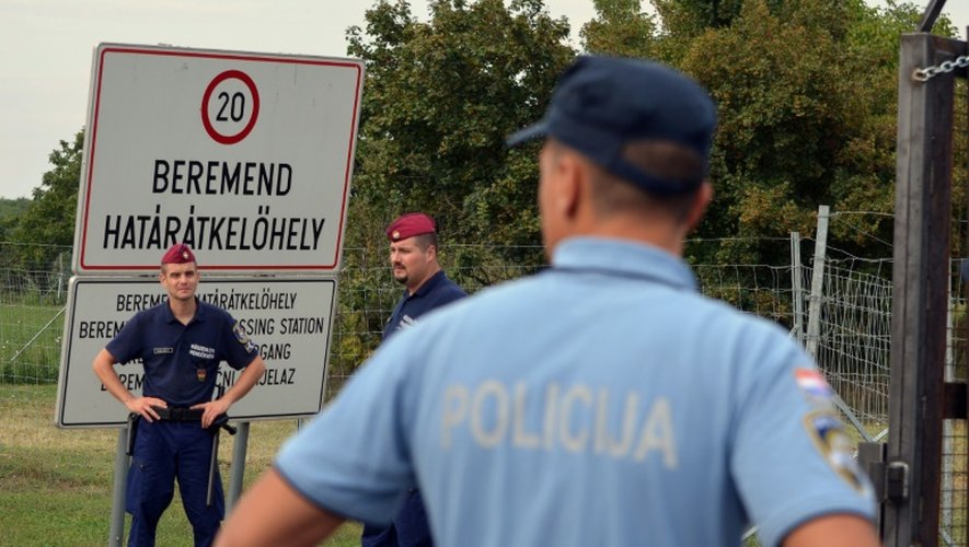 Forces de sécurité hongroises (face) et croate (de dos) me 20 septembre 2015 à Beremend à la frontière de la Hongrie et de la Croatie
