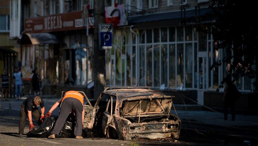 Un corps est retiré d'une voiture après son explosion à Donetsk le 27 août 2014