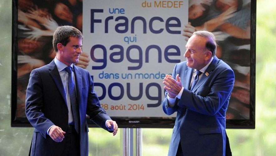 Le Premier ministre Manuel Valls applaudi par Pierre Gattaz à l'université d'été du Medef le 27 septembre 2014 à Jouy-en-Josas