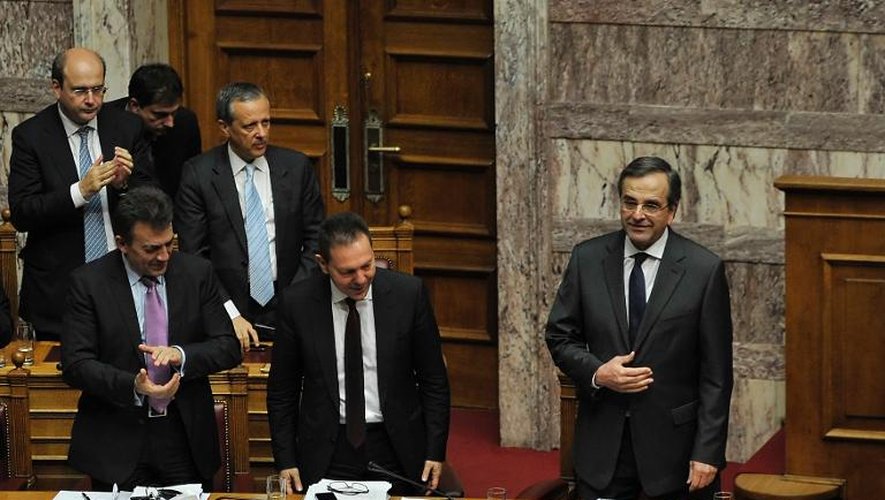 Le Premier ministre grec Antonis Samaras (d) applaudit à l'issue de son discours au Parlement, avant le vote du budget 2014, le 7 décembre 2013 à Athènes
