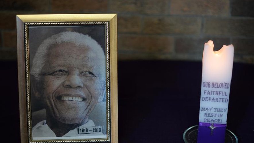 Une bougie placée à côté d'une photo de Nelson Mandela lors d'une messe à Soweto, le 8 décembre 2013