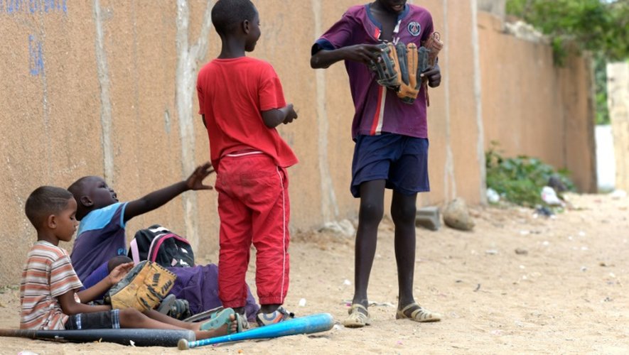 Des enfants jouent au base-ball sur un terrain de jeu improvisé, le 14 juillet 2016, dans le quartier défavorisé de Oukam, dans le nord de Dakar
