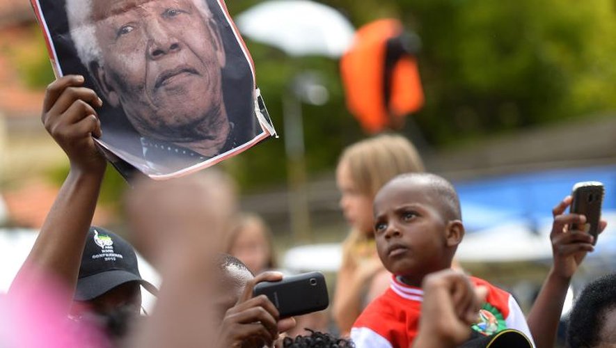 Un portrait de Mandela brandi le 8 décembre 2013 devant son domicile à Houghton
