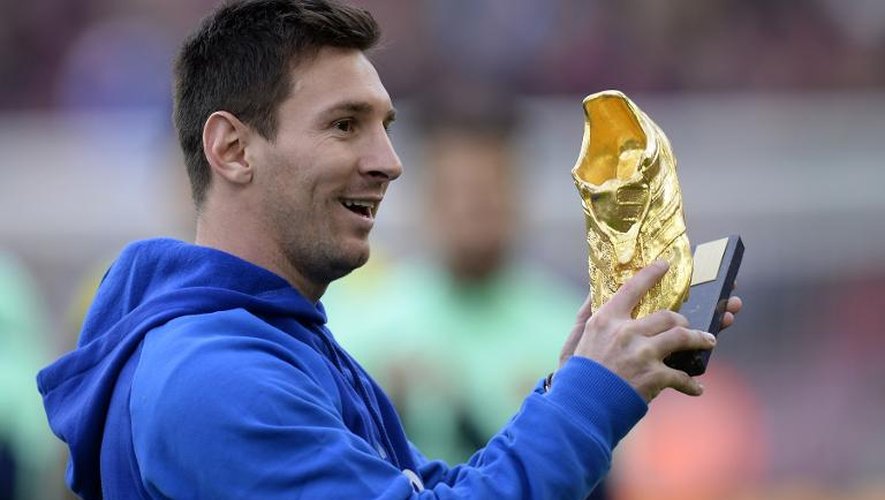 L'attaquant du FC Barcelone Lionel Messi présente son Soulier d'or 2013, qui récompense le meilleur buteur européen, au Camp Nou le 23 novembre 2013