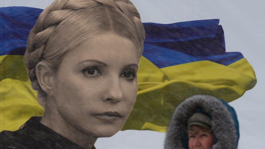 Une manifestante ukrainienne à Kiev devant un poster géant de l'ex-Première ministre Yulia Tymoshenko, le 9 décembre 2013