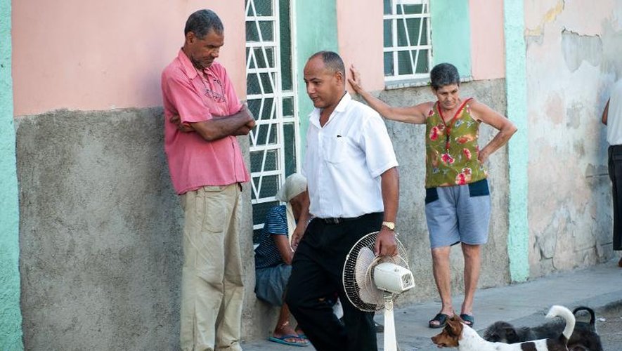 Un Cubain transporte un ventilateur dans une rue de La Havane, le 27 août 2014, alors que la canicule bat son plein avec des températures ressenties de plus de 48°