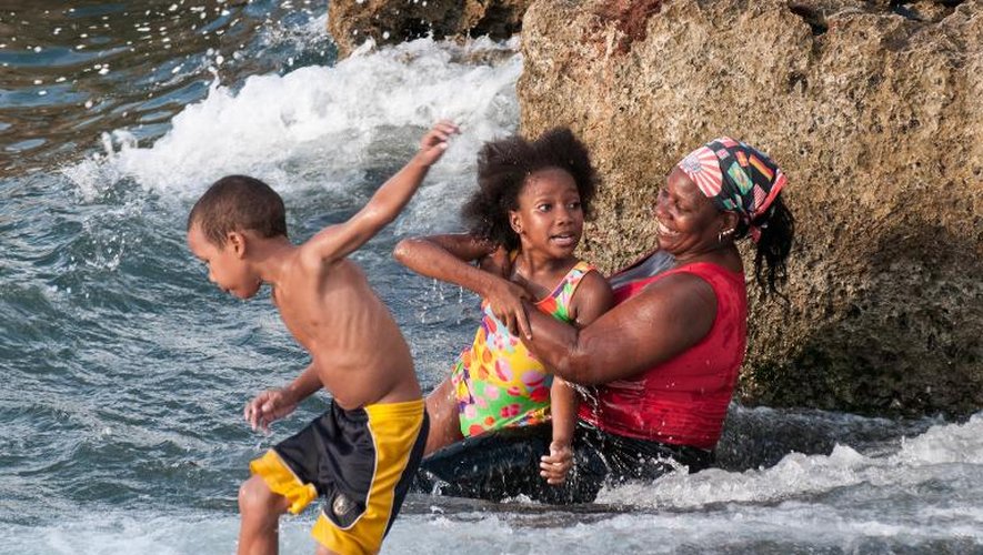 Une famille cubaine se rafraîchit sur une plage à La Havane, le 27 août 2014 alors que les températures ressenties avoisinent les 48°