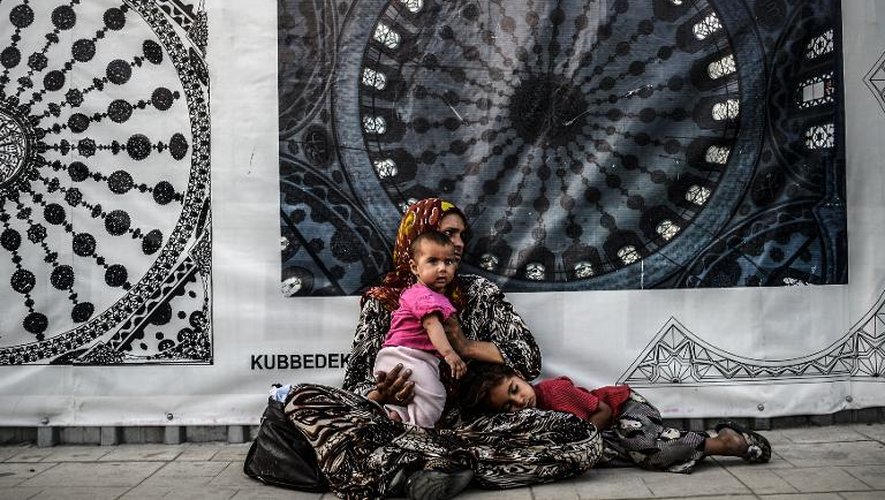 Une réfugiée syrienne mendie avec son enfant dans une rue d'Istanbul, le 16 juillet 2014
