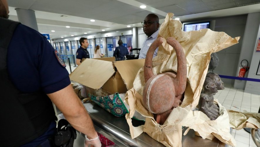 Les douaniers contrôlent des cartons remplis de statuettes africaines et tout juste débarqués d'un avion en provenance du Cameroun, le 26 juillet 2016 à l'aéroport de Roissy-Charles-de-Gaulle
