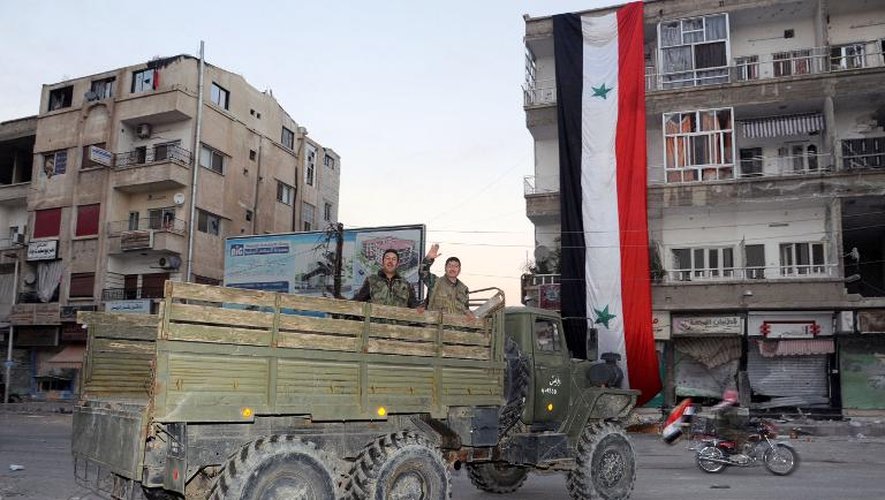 Des soldats du régime syrien se déplacent à bord d'un véhicule militaire après avoir repris aux rebelles la ville de Nabak dans la région de Qalamoun, le 9 décembre 2013