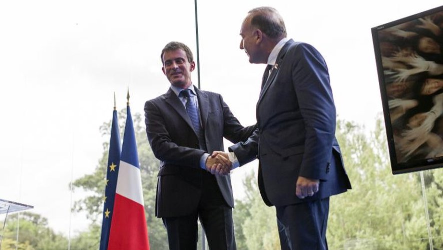 Le Premier ministre français Manuel Valls serre la main du président du Medef Pierre Gattaz lors de l'université d'été de l'organisation patronale, le 27 août 2014 à Jouy-en-Josas (Yvelines)