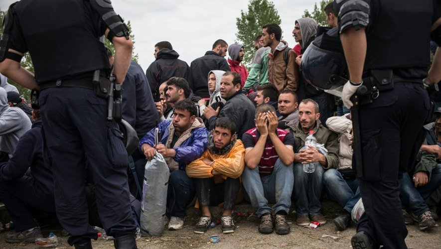 Des policiers croates devant des migrants et réfugiés qui attendent d'entrer dans le centre de transit d'Opatovac en Croatie, le 22 septembre 2015