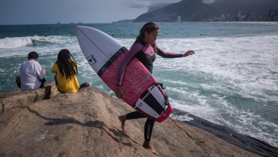 Une surfeuse s'apprête à s'adonner à son sport sur la plage d'Ipanema, à Rio de Janiero, le 30 juillet 2016
