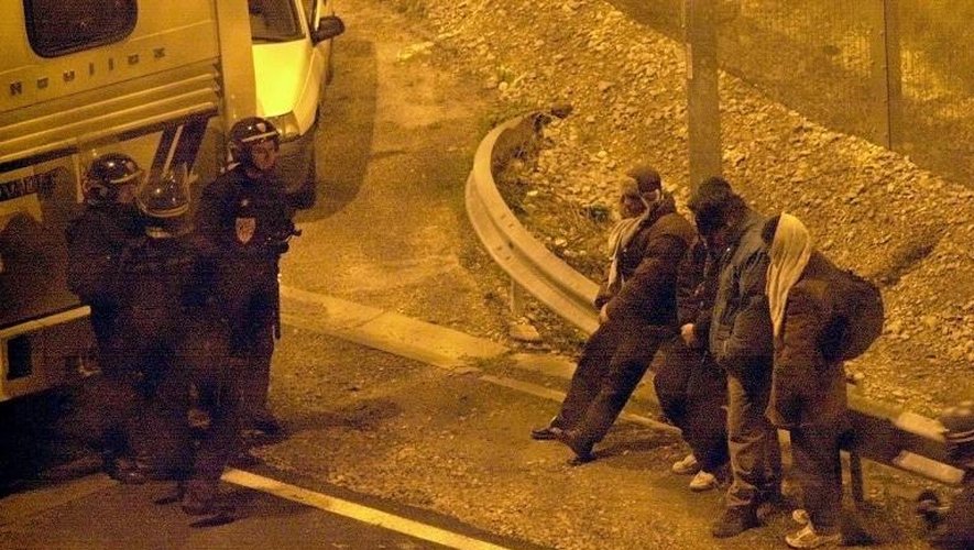 Des CRS surveillent, dans la nuit du 25 au 26 décembre 2001 à Coquelles, des clandestins du centre de la Croix Rouge de Sangatte qui avaient pénétré dans le terminal fret d'Eurotunnel