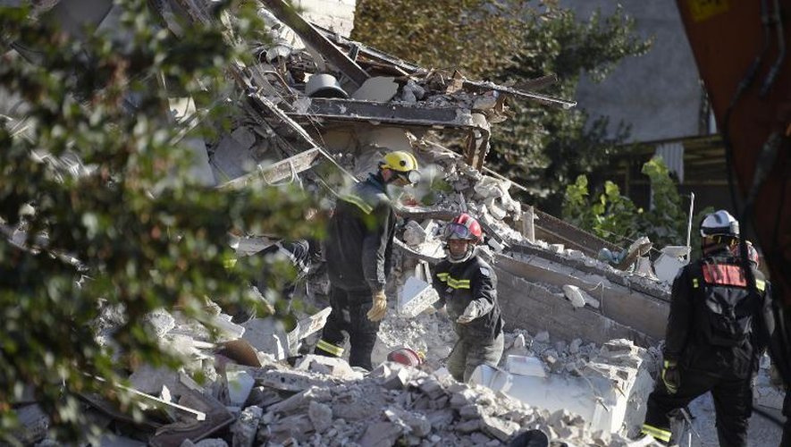 Des pompiers fouillent le 1er septembre 2014 avec une tractopelle les décombres de l'immeuble qui s'est effondré à Rosny-sous-Bois