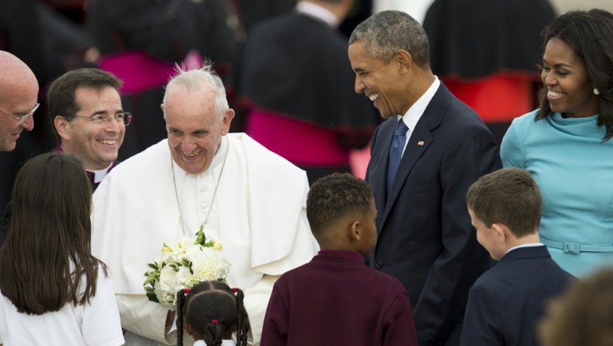 Le pape François, entouré de Barack et Michelle Obama, reçoit des fleurs à son arrivée à la base aérienne d'Andrews dans le Maryland, le 22 septembre 2015 aux Etats-Unis
