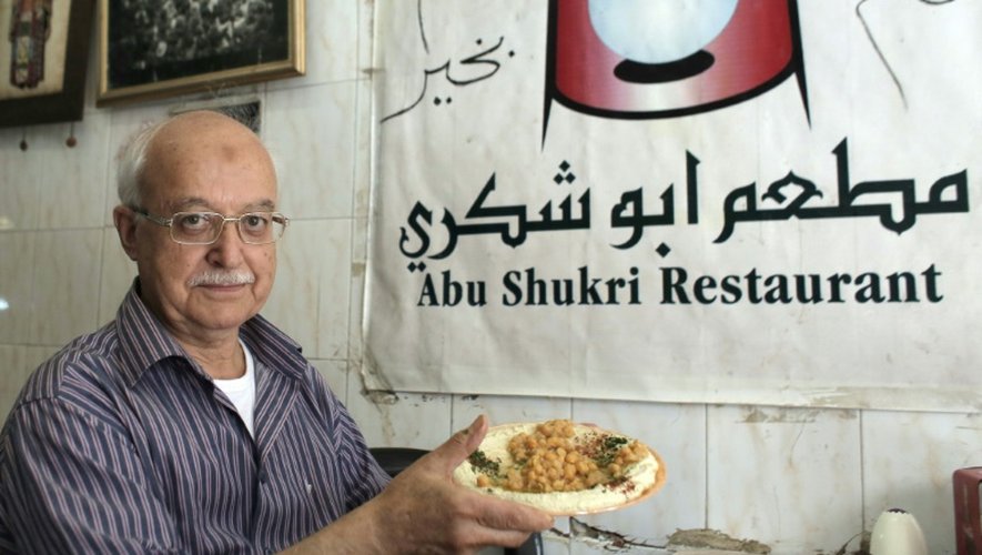 Yasser Taha, patron du restaurant palestinien Abou Choukri, pose avec une assiette de houmous, le 12 septembre 2015 à Jérusalem