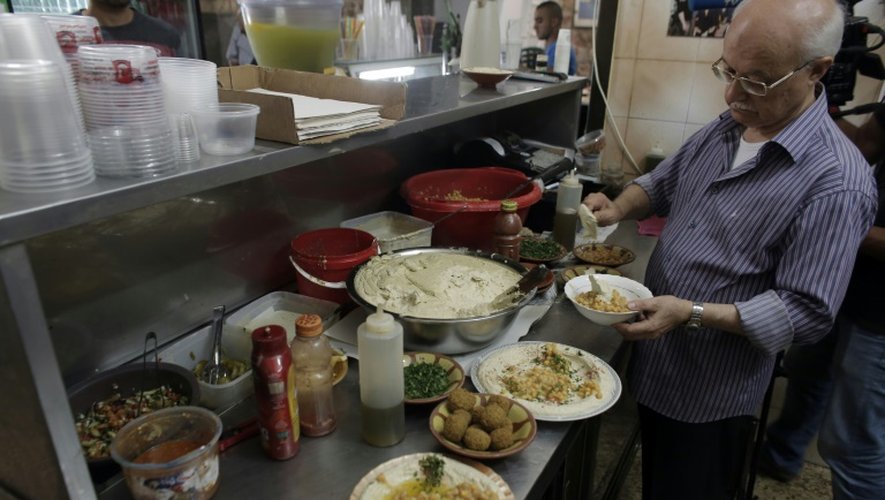 Yasser Taha, patron du restaurant palestinien Abou Choukri, prépare des assiettes de houmous, le 12 septembre 2015 à Jérusalem