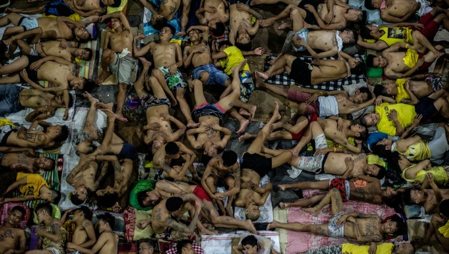 Des détenus dorment les uns sur les autres sur le terrain de basket de la prison surpeuplée de Quezon City, à Manille, le 19 juillet 2016