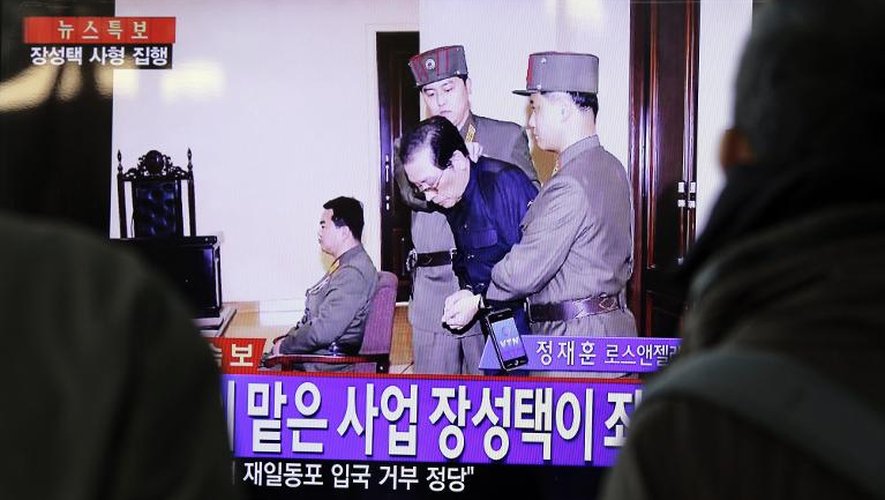 Des Sud-Coréens regardent à la télévision le 123 décembre 2013 à Séoul, Jang Song-thaek emmené par des gardes à la sortie du tribunal peu avant son éxécution
