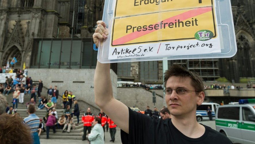 Un contre-manifestant brandit un panneau demandant la "liberté de la presse" en Turquie, à Cologne le 31 juillet 2016