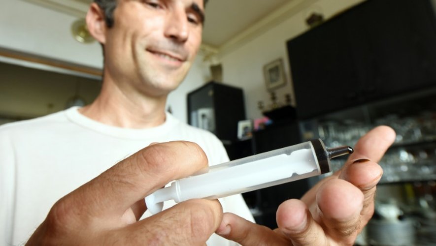 Huanito Luksetic, atteint de sclérose en plaques, tient une seringue d'huile de cannabis dans ses mains, le 13 juillet 2016 à Rijeka en Croatie