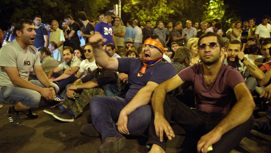 Des manifestants bloquent une rue menant vers le commissariat de police à Erevan occupé par des opposants armés, le 31 juillet 2016