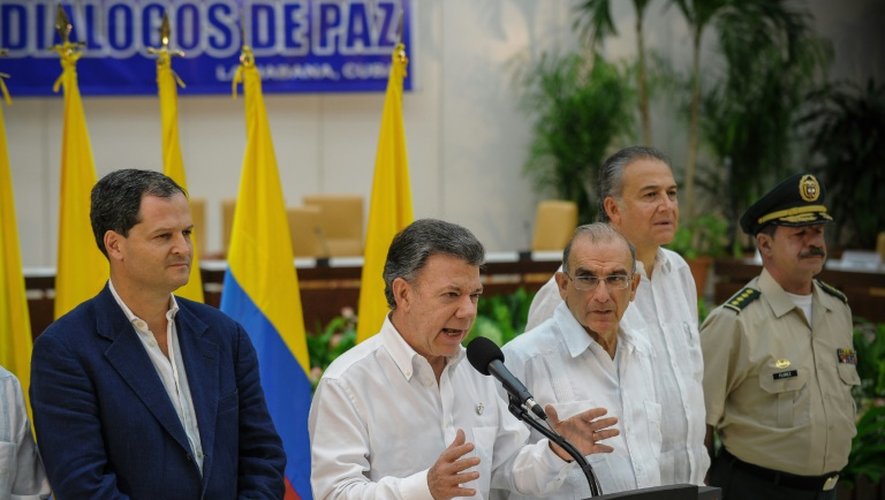 Le président colombien Juan Manuel Santos (2g), entouré du chef de la délégation colombienne pour le dialogue de paix avec les Farc, Humberto de la Calle (3e d) et un membre de la délégation Sergio Jaramillo (g), lors d'une conférence de presse à La Havane, le 23 septembre 2015