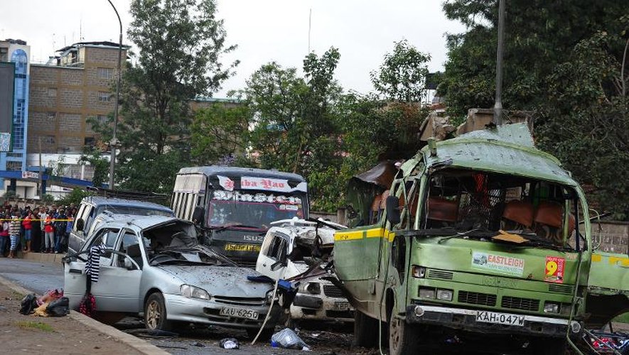 Des personnes se tiennent près du lieu d'une explosion qui a soufflé un bus le 14 décembre 2013 à Nairobi, au Kenya